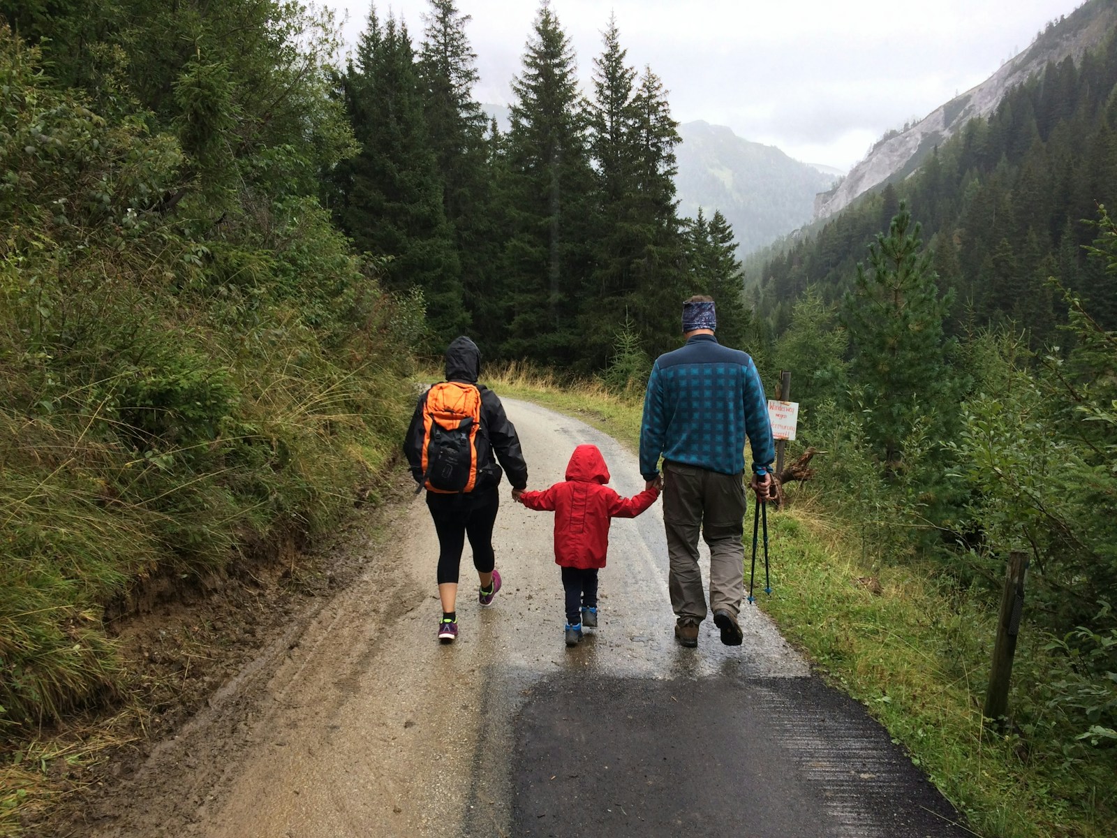 Família com criança caminhando por uma trilha na montanha