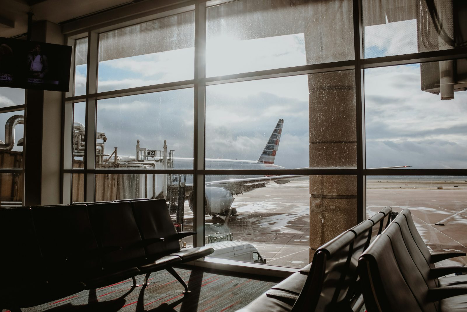 Sala de embarque com avião ao fundo em aeroporto internacional